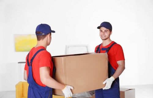 Local movers navigating stairs in a Highbury flat building
